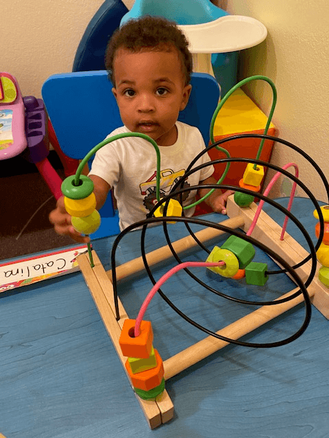 Little one exploring with a bead maze toy