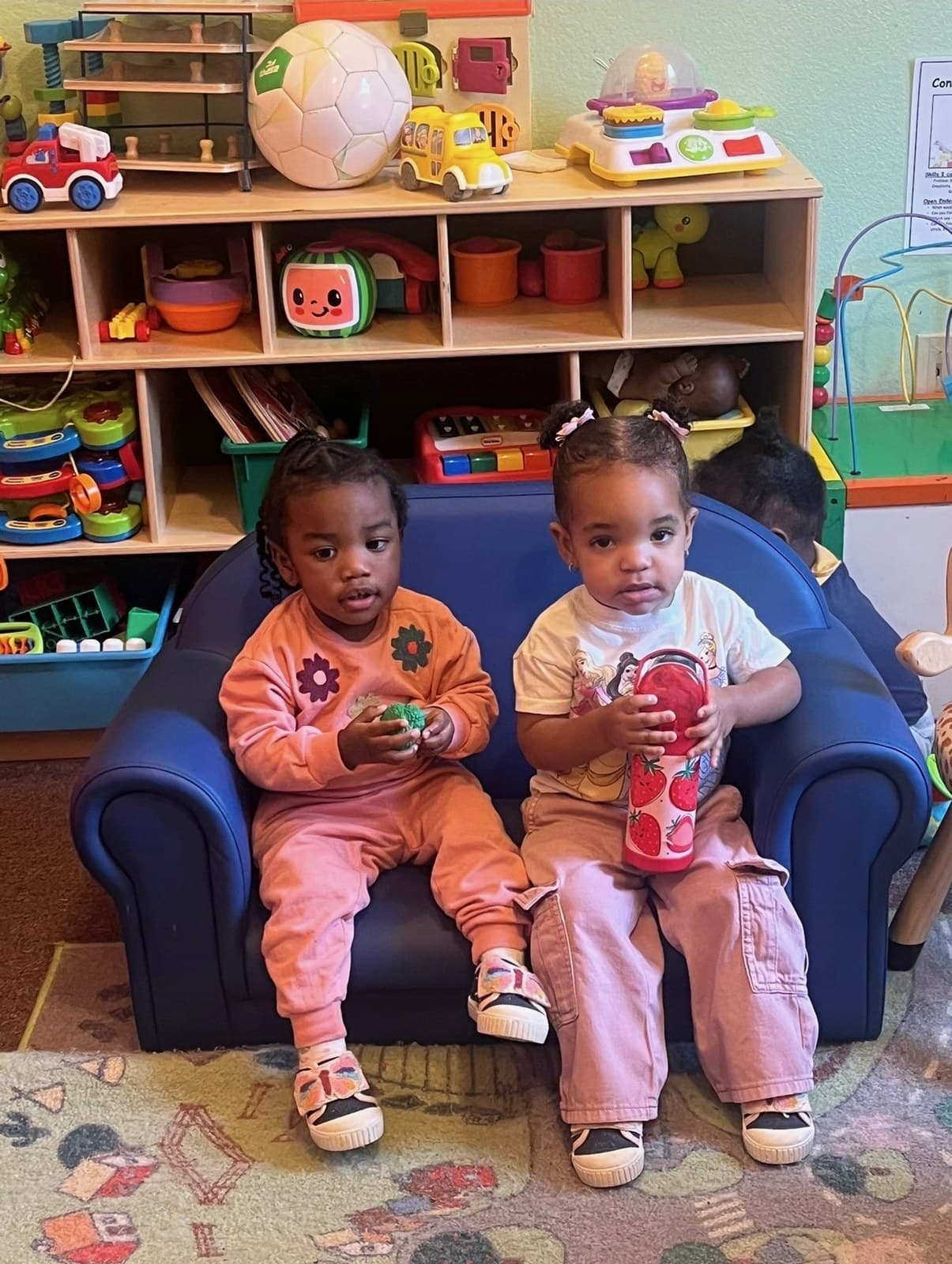 Toddler friends sharing a cozy spot in the playroom